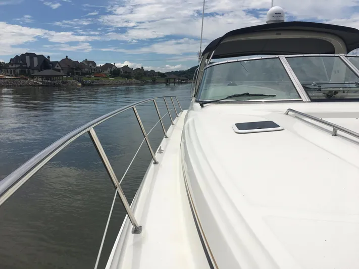  Yacht Photos Pics 2000 Sea Ray 410 Sundancer yacht cruising on a calm river under a partly cloudy sky.