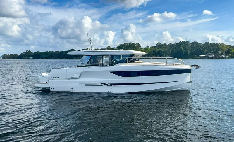  Yacht Photos Pics 2025 Wellcraft 44 Explorer yacht on a serene lake under a partly cloudy sky.