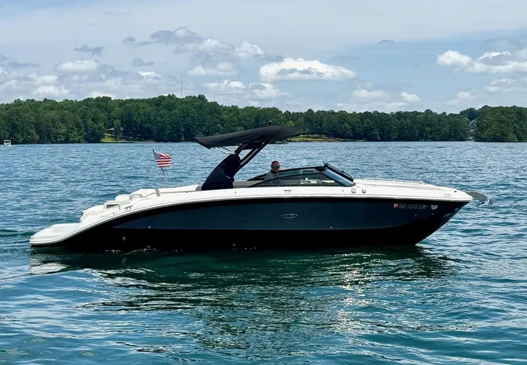  Yacht Photos Pics 2020 Sea Ray 290SDX boat cruising on a lake under a partly cloudy sky.
