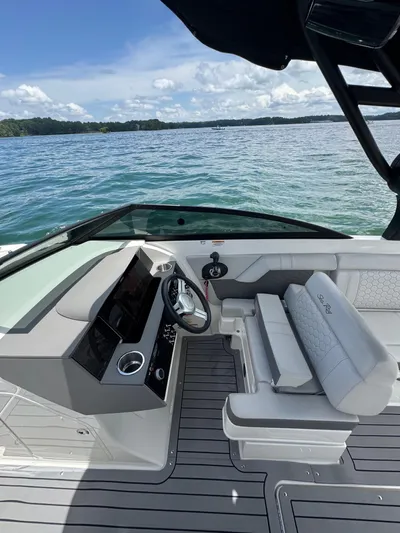  Yacht Photos Pics 2020 Sea Ray 290SDX boat interior with helm, steering wheel, and seating, overlooking serene water.