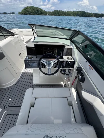  Yacht Photos Pics 2020 Sea Ray 290SDX boat interior with steering wheel, on a sunny day by the water.