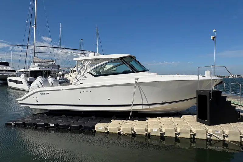 Sheminem Yacht Photos Pics 2023 Pursuit DC 295 Dual Console boat docked at marina under clear blue sky.