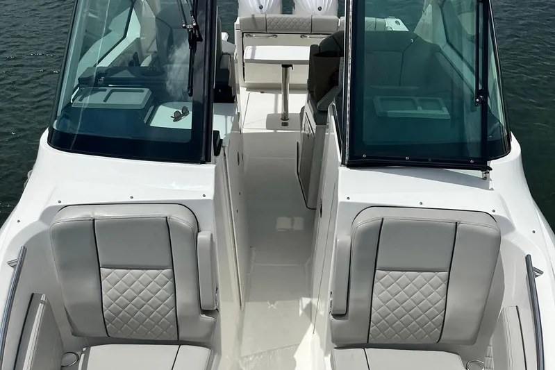Sheminem Yacht Photos Pics 2023 Pursuit DC 295 Dual Console boat interior with cushioned seating and windshield.