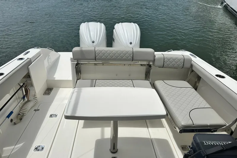 Sheminem Yacht Photos Pics 2023 Pursuit DC 295 Dual Console boat interior with seating and table on water.