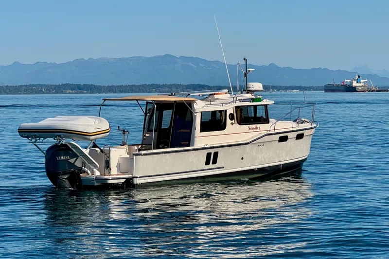 Noodles Yacht Photos Pics 2024 Ranger Tugs R-27 boat on calm water with distant mountains.