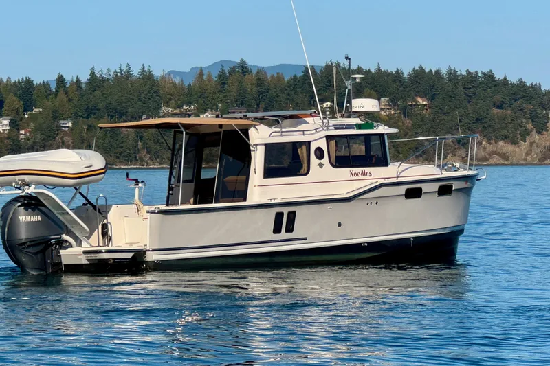 Noodles Yacht Photos Pics 2024 Ranger Tugs R-27 boat on calm water with scenic forested background.
