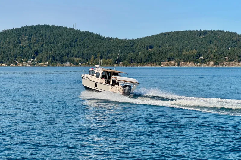 Noodles Yacht Photos Pics 2024 Ranger Tugs R-27 cruising on a scenic lake with forested hills.