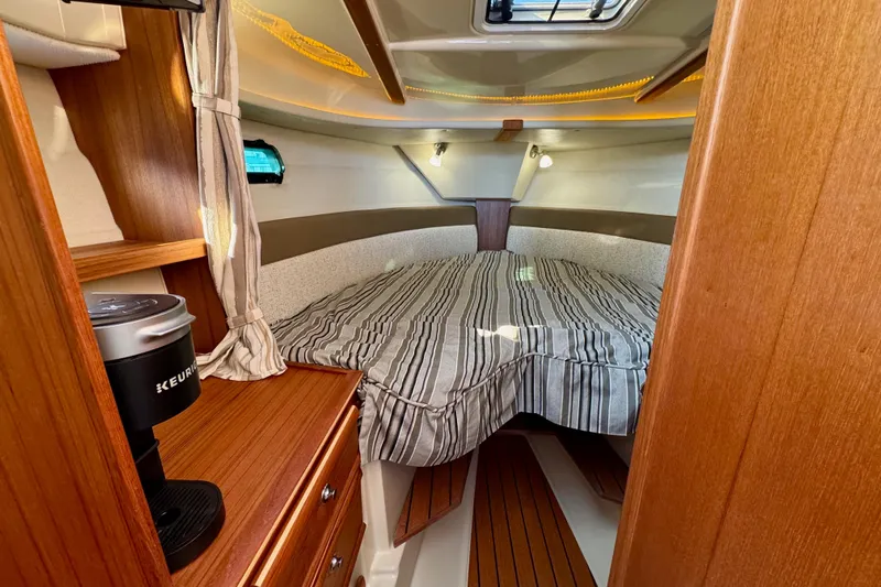 Noodles Yacht Photos Pics 2024 Ranger Tugs R-27 cabin interior with bed and wooden cabinetry.