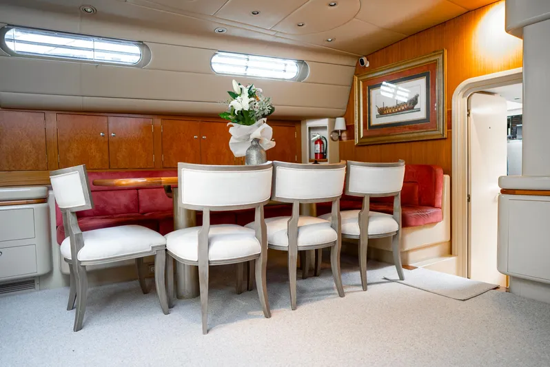 Eclipse Yacht Photos Pics Luxurious yacht interior with elegant dining area, featuring white chairs and a floral centerpiece.