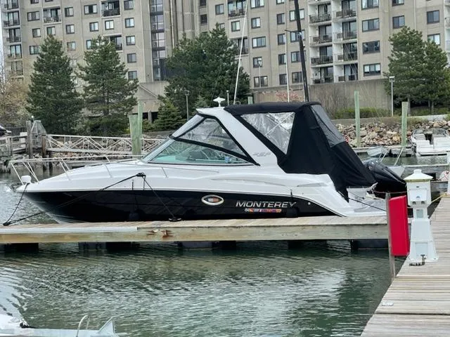  Yacht Photos Pics 2021 Monterey 295 Sport Yacht docked in marina, cityscape background.