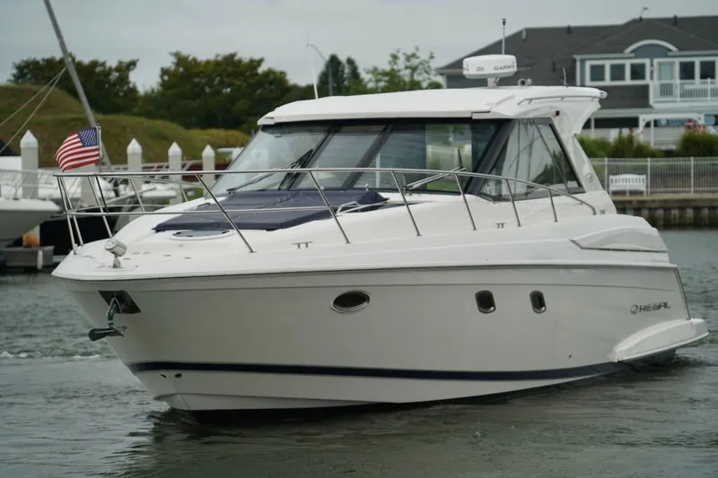  Yacht Photos Pics 2012 Regal 42 Sport Coupe yacht cruising in a marina with American flag.