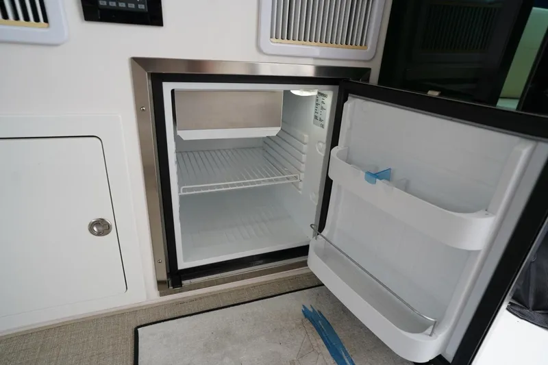 Yacht Photos Pics Open mini fridge inside 2012 Regal 42 Sport Coupe yacht, showcasing interior storage space.