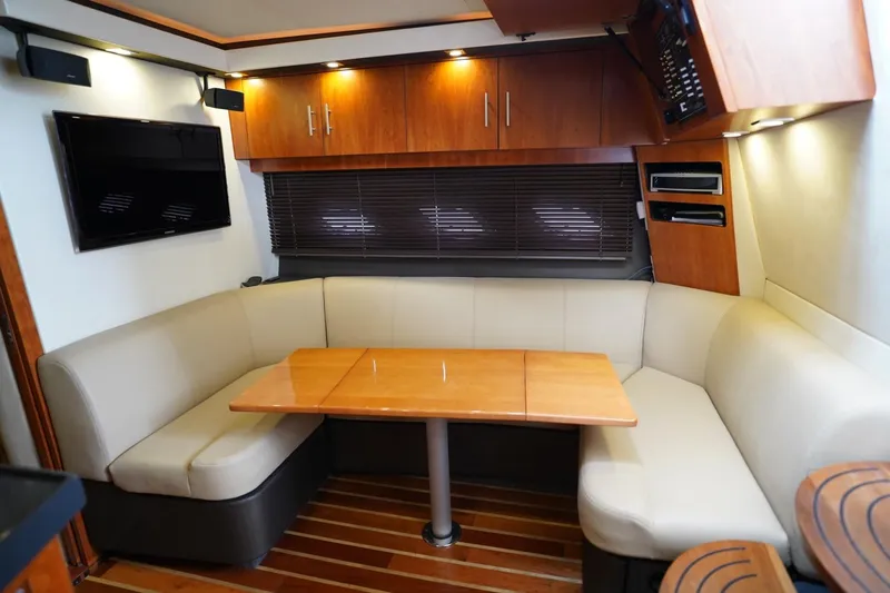  Yacht Photos Pics Interior of 2012 Regal 42 Sport Coupe with cozy seating and wooden table.
