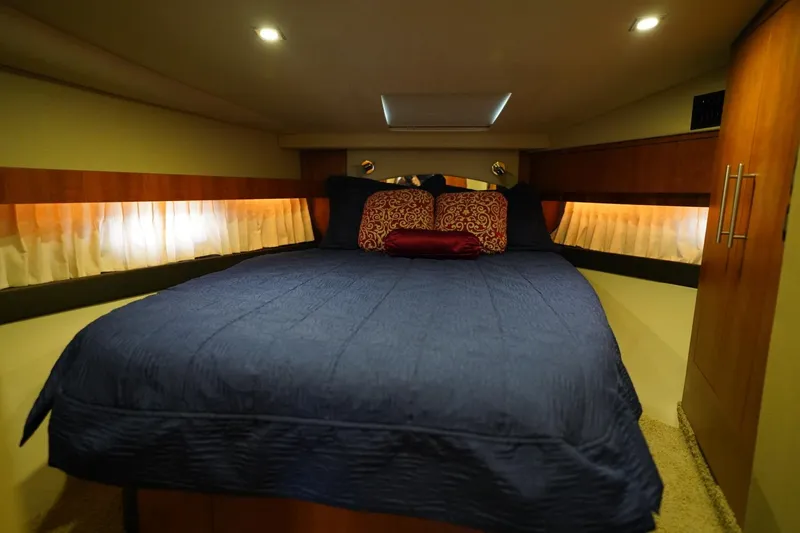  Yacht Photos Pics Luxurious cabin interior of 2012 Regal 42 Sport Coupe with cozy bedding and ambient lighting.