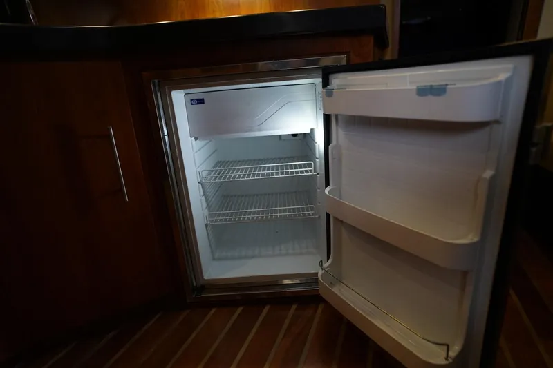  Yacht Photos Pics Open mini fridge inside 2012 Regal 42 Sport Coupe yacht, showcasing interior shelves.