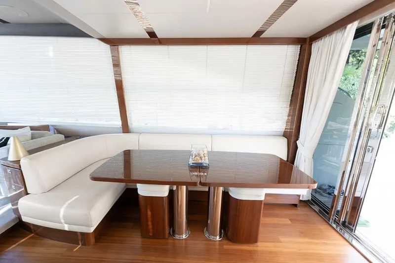 Daphne Yacht Photos Pics Luxurious dining area on a 2018 Princess 68 yacht with elegant wood and white seating.