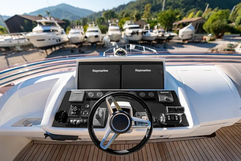 Daphne Yacht Photos Pics Helm of 2018 Princess 68 yacht with Raymarine navigation system, docked with other boats.