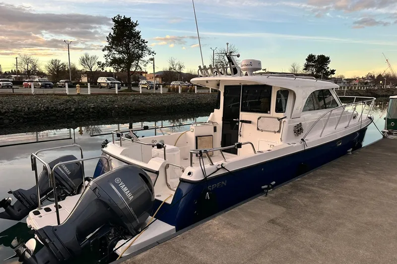  Yacht Photos Pics 2019 Aspen C107 boat docked with dual Yamaha outboard engines, under a cloudy sky.