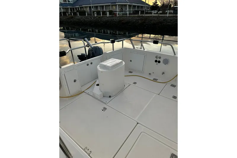  Yacht Photos Pics 2019 Aspen C107 boat deck with storage compartments and railing, docked by the water.
