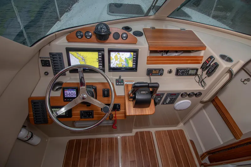  Yacht Photos Pics 2019 Aspen C107 boat cockpit with navigation screens and wooden accents.