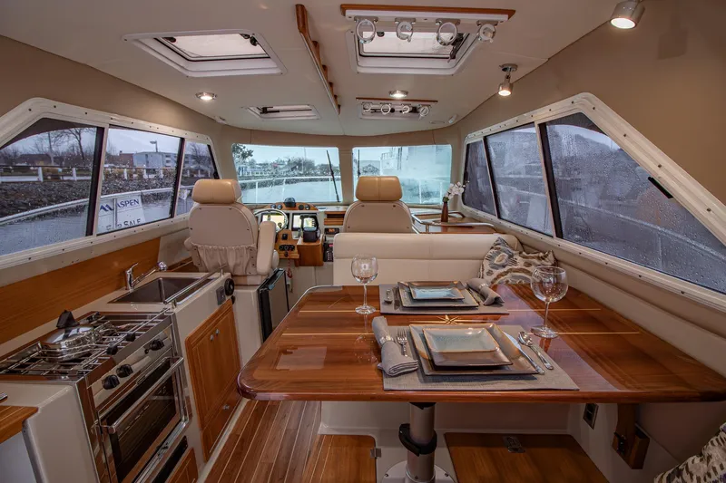  Yacht Photos Pics Luxurious interior of 2019 Aspen C107 boat with dining area and kitchen amenities.