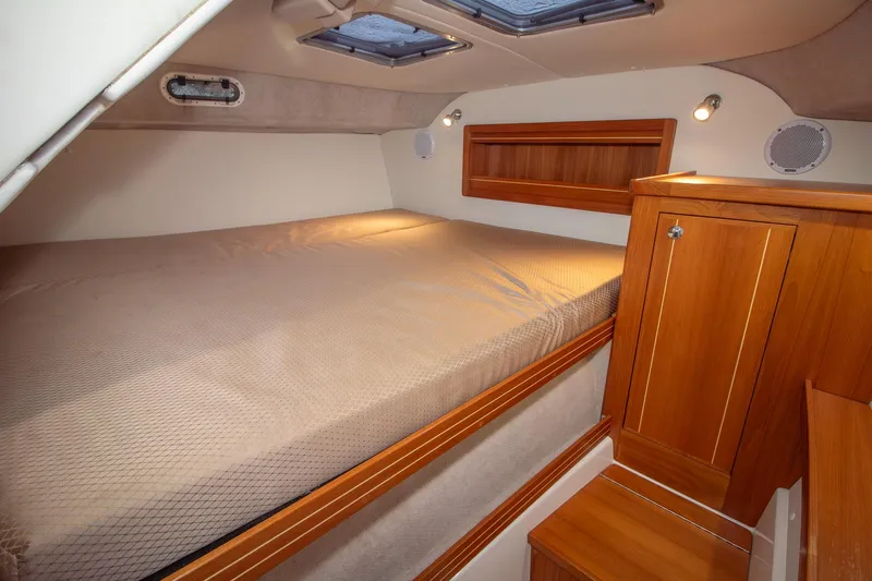  Yacht Photos Pics Cozy cabin interior of 2019 Aspen C107 boat with wooden cabinetry and bed.