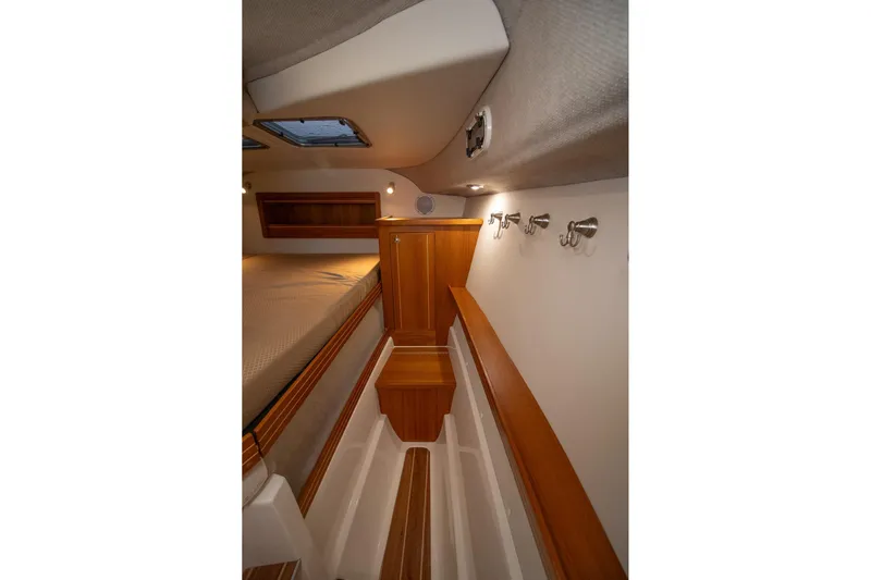  Yacht Photos Pics 2019 Aspen C107 boat interior with wooden cabinetry and cozy sleeping area.