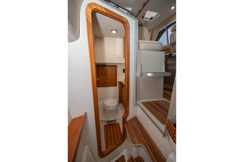 Yacht Photos Pics 2019 Aspen C107 boat interior with wooden accents and compact bathroom.
