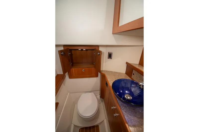  Yacht Photos Pics Compact bathroom in 2019 Aspen C107 boat with blue sink and wooden cabinetry.