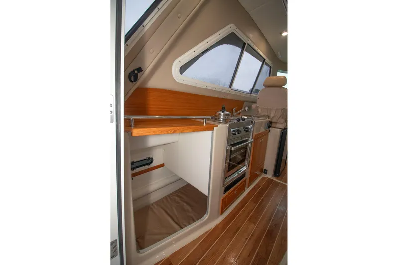  Yacht Photos Pics Compact kitchen area in 2019 Aspen C107 boat with stove, oven, and wooden flooring.