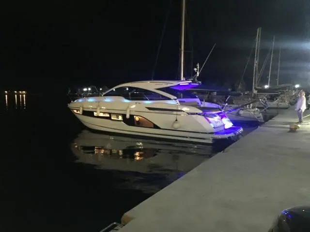  Yacht Photos Pics 2021 Fairline Targa 45 Open yacht docked at night, illuminated by blue lights.
