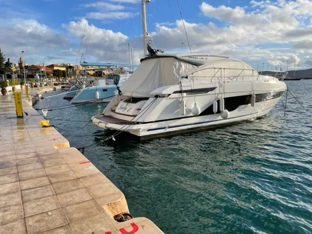  Yacht Photos Pics 2021 Fairline Targa 45 Open yacht docked at a marina under a cloudy sky.