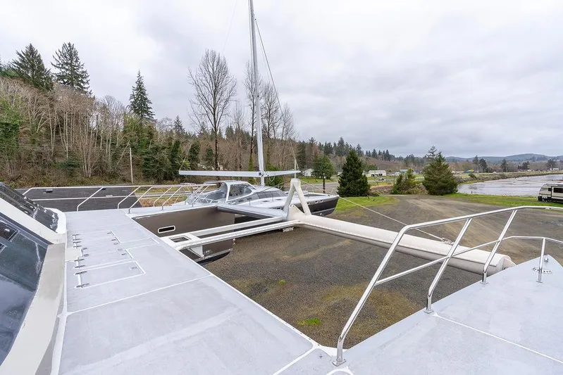 Mai Cat Yacht Photos Pics 2025 Catamaran Bloomfield 86 Motorsailor on land, surrounded by trees and overcast sky.