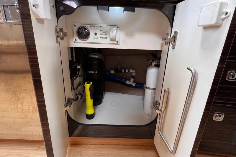 Love Shact Yacht Photos Pics Open cabinet in 2012 Formula 37 PC boat showing water system controls and equipment.