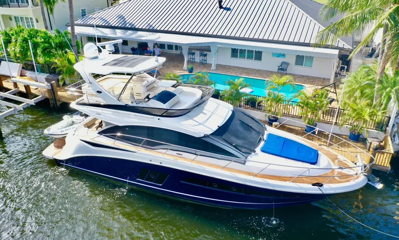  Yacht Photos Pics 2015 Sea Ray 510 Fly yacht docked near a waterfront home with a pool.