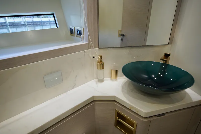  Yacht Photos Pics Luxurious bathroom in 2024 Uniesse HTC5P yacht with modern sink and gold accents.