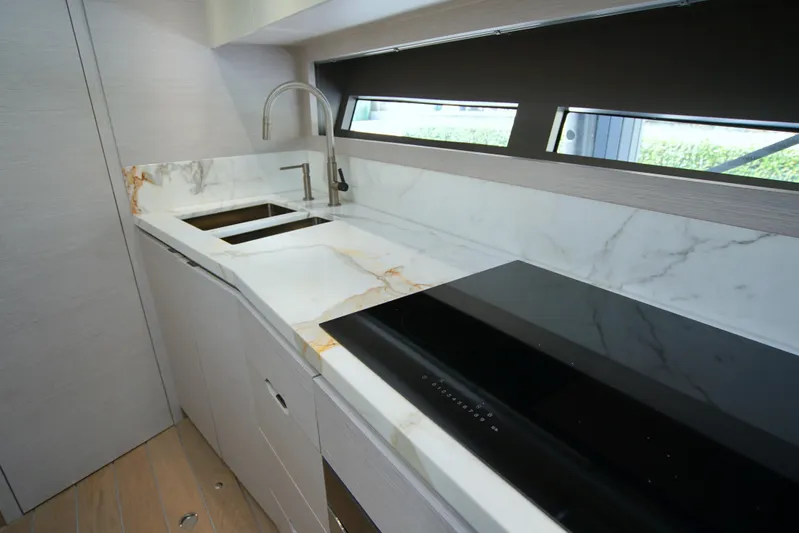  Yacht Photos Pics Modern kitchen in 2024 Uniesse HTC5P yacht with marble countertops and sleek appliances.