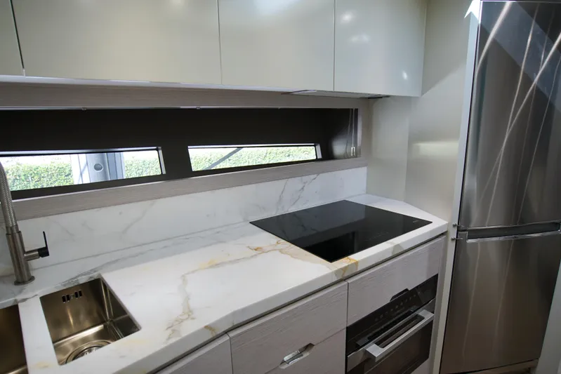  Yacht Photos Pics Modern kitchen in 2024 Uniesse HTC5P yacht with sleek appliances and marble countertops.