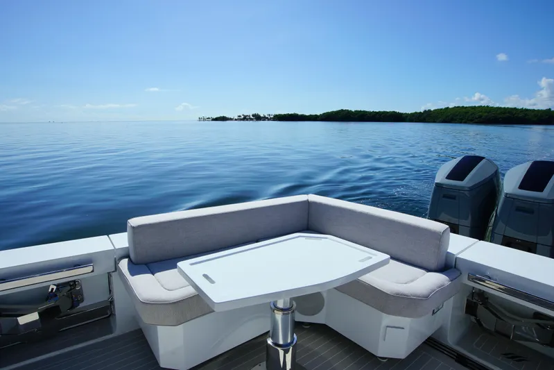  Yacht Photos Pics 2024 Uniesse HTC5P yacht deck with seating, table, and ocean view.