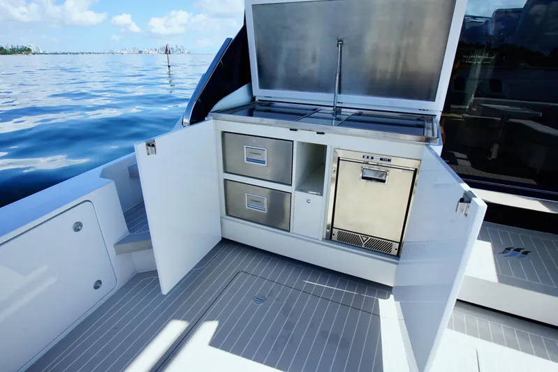 Yacht Photos Pics Outdoor kitchen on 2024 Uniesse HTC5P yacht with storage and appliances, overlooking calm waters.