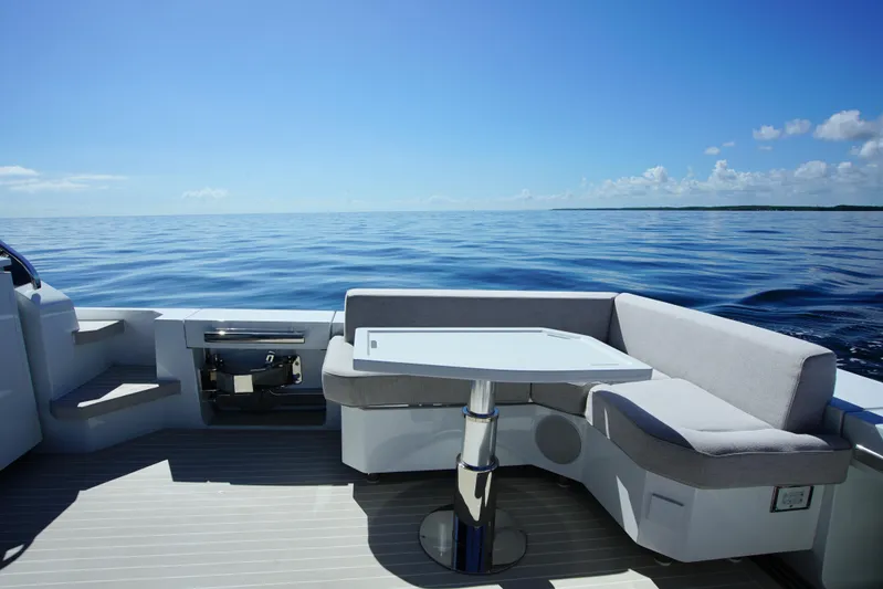  Yacht Photos Pics Luxurious 2024 Uniesse HTC5P yacht deck with seating, table, and ocean view.
