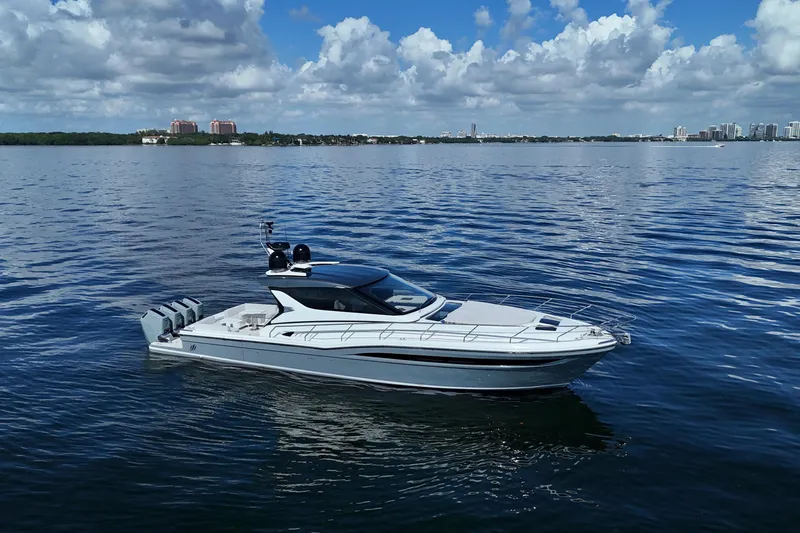 Yacht Photos Pics 2024 Uniesse HTC5P luxury yacht cruising on calm waters under a partly cloudy sky.