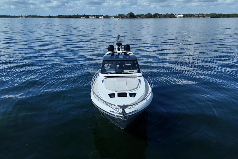  Yacht Photos Pics 2024 Uniesse HTC5P yacht on calm blue water under a partly cloudy sky.