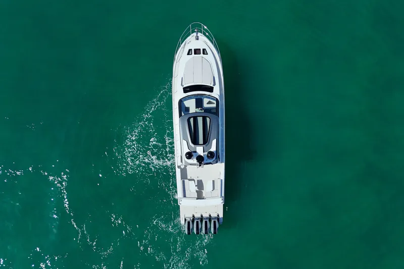  Yacht Photos Pics Aerial view of 2024 Uniesse HTC5P yacht cruising in clear turquoise waters.