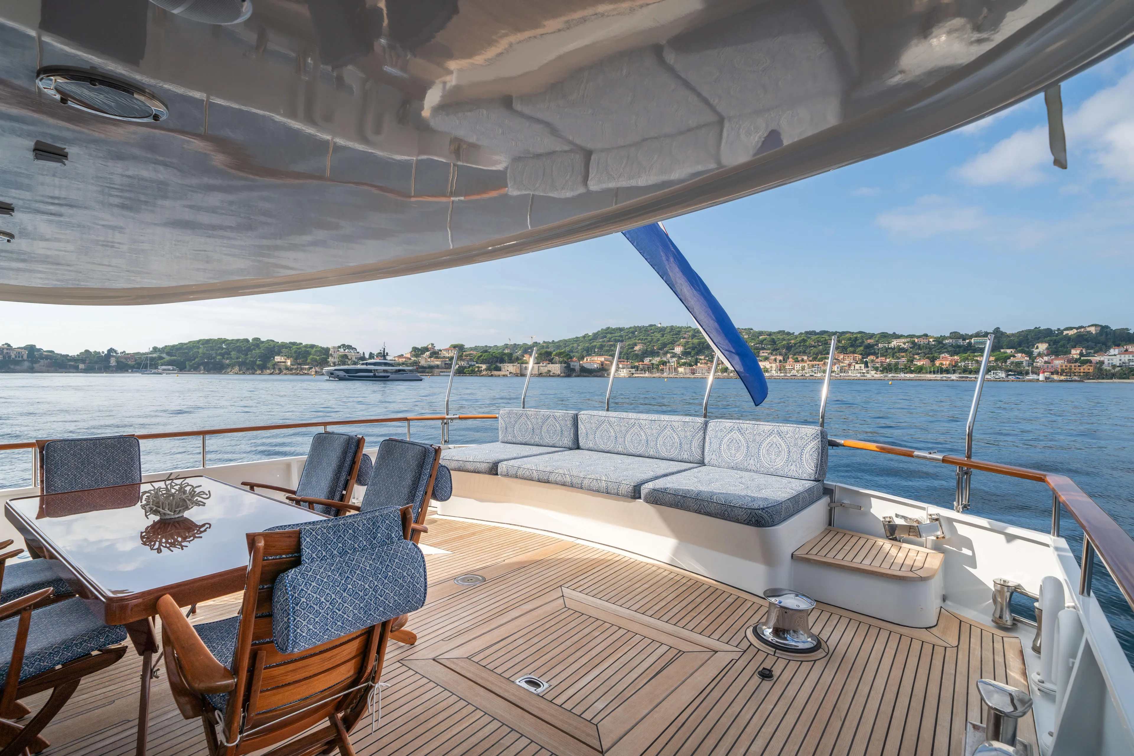 Bluemar II Yacht Photos Pics 1978 Feadship Classic yacht deck with seating and dining area, overlooking scenic waterfront.