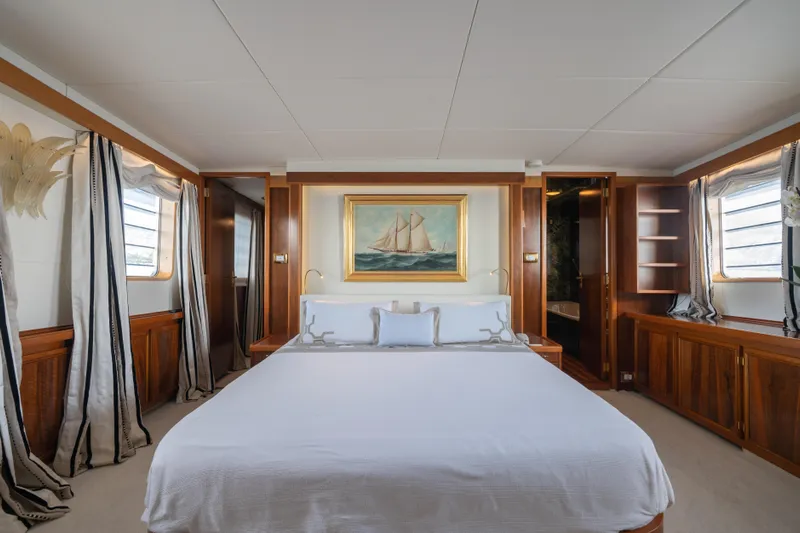 Bluemar II Yacht Photos Pics Luxurious bedroom on a 1978 Feadship Classic yacht with elegant wood finishes and nautical decor.