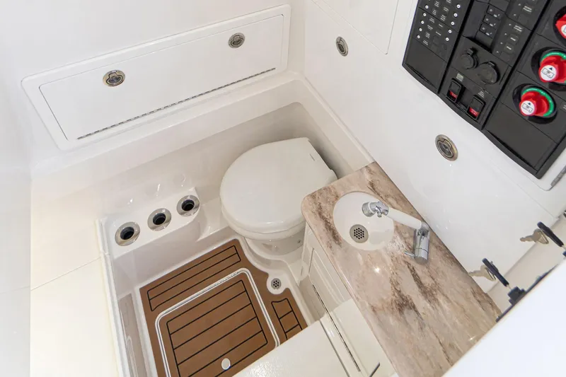 Archie Yacht Photos Pics 2021 Valhalla Boatworks V-33 interior bathroom with toilet, sink, and control panel.