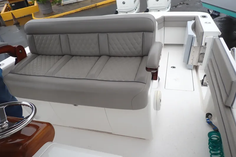 Archie Yacht Photos Pics 2021 Valhalla Boatworks V-33 interior with gray cushioned seating and steering wheel.