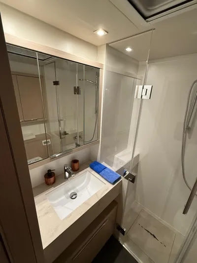 Jdmontt Yacht Photos Pics 2024 Lagoon 55 yacht bathroom with modern sink, mirror, and glass shower enclosure.