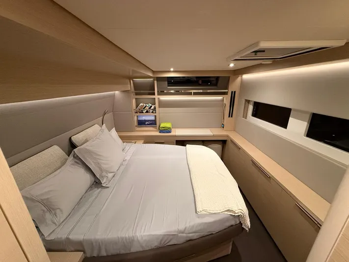Jdmontt Yacht Photos Pics Luxurious cabin interior of 2024 Lagoon 55 yacht with modern design and cozy bedding.